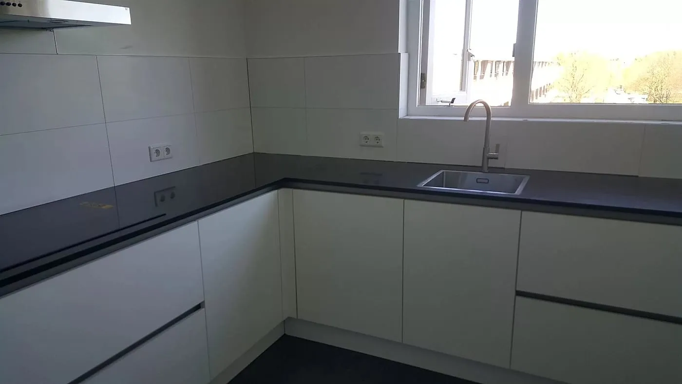 Witte keuken met antracieten blad na de renovatie — keukenrenovatie in De Wijert door BontBouw