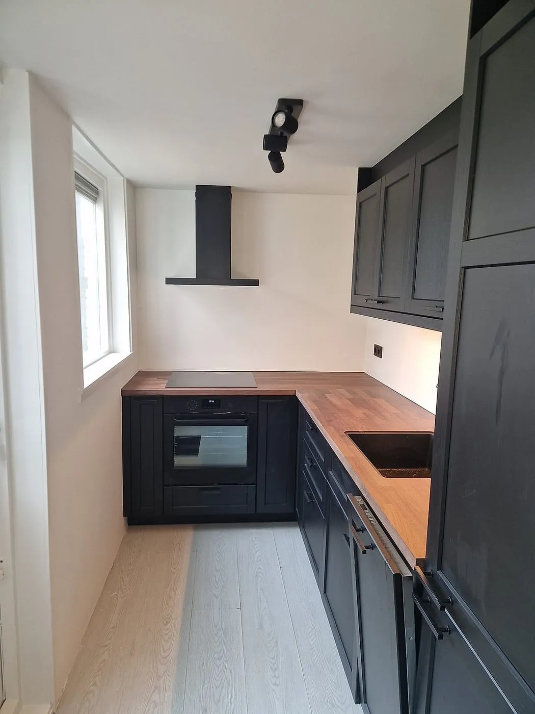 Zwarte keuken met houten werkblad na de renovatie — keukenrenovatie in Leeuwarden door BontBouw