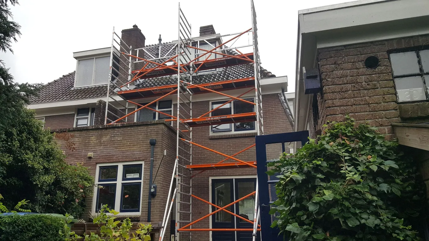 Achtergevel met rolsteiger tot aan de dakkapel vóór het werk — schilderwerk in Assen door BontBouw