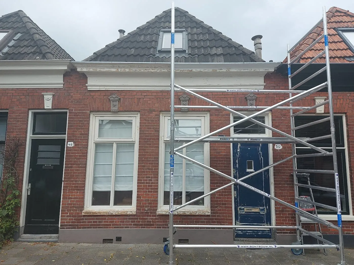 Afbladderende daklijst met steiger vóór het werk — schilderwerk in Korrewegwijk door Bontbouw