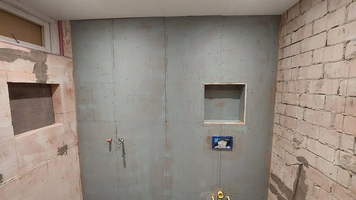 Doucheruimte in ruwbouw met waterdichte platen vóór de renovatie — badkamerrenovatie in Sauwerd door BontBouw