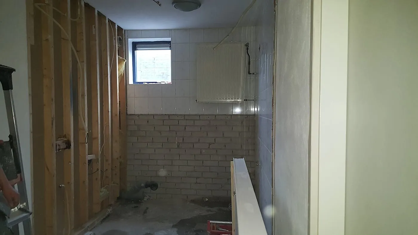 Gestripte badkamer met houten regelwerk vóór de renovatie — badkamerrenovatie in De Hunze door BontBouw