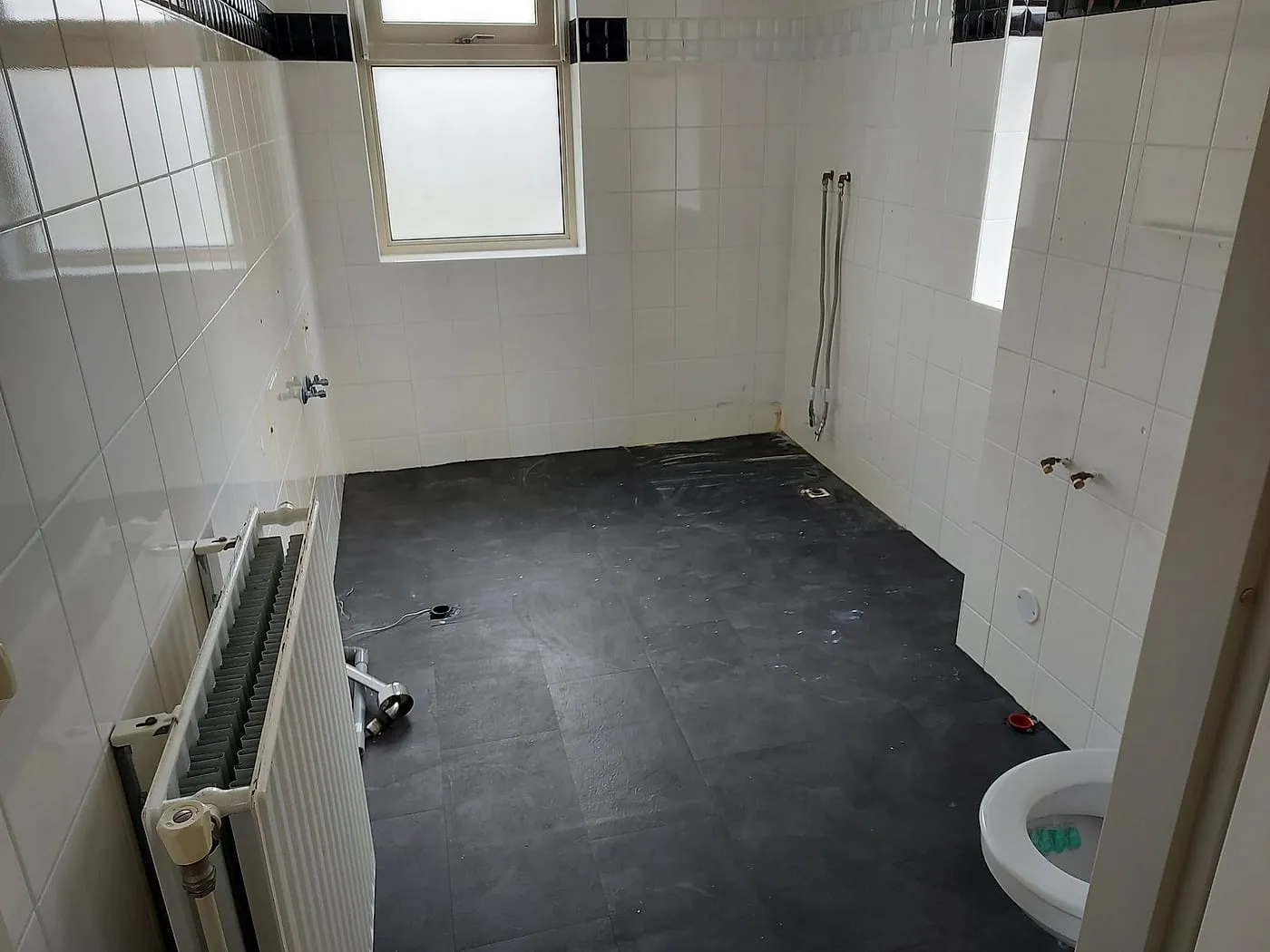 Gestripte badkamer met witte tegels vóór de renovatie — badkamerrenovatie in Bedum door BontBouw