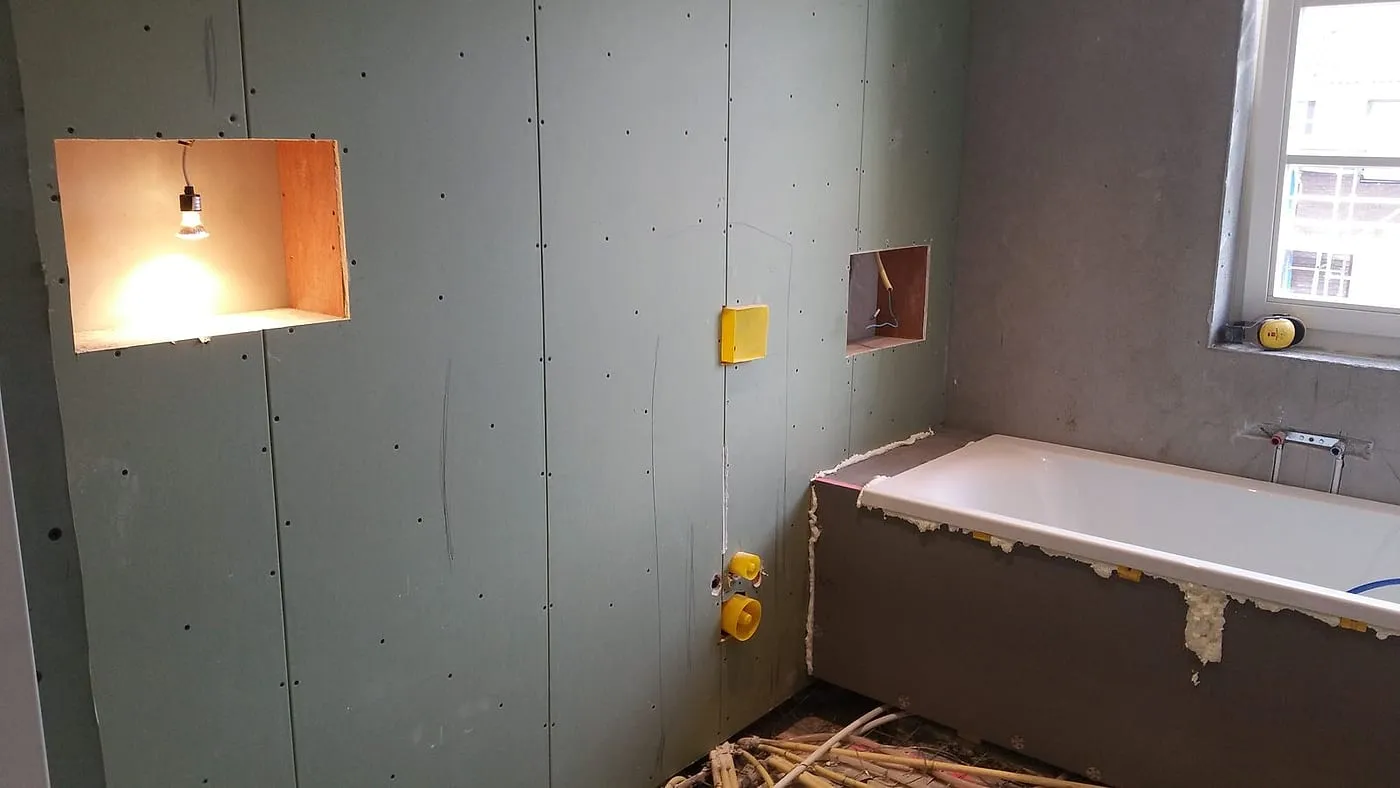 Gipsplaatwanden met uitgespaarde nis en ingebouwd ligbad vóór de renovatie — badkamerrenovatie in Haren door BontBouw