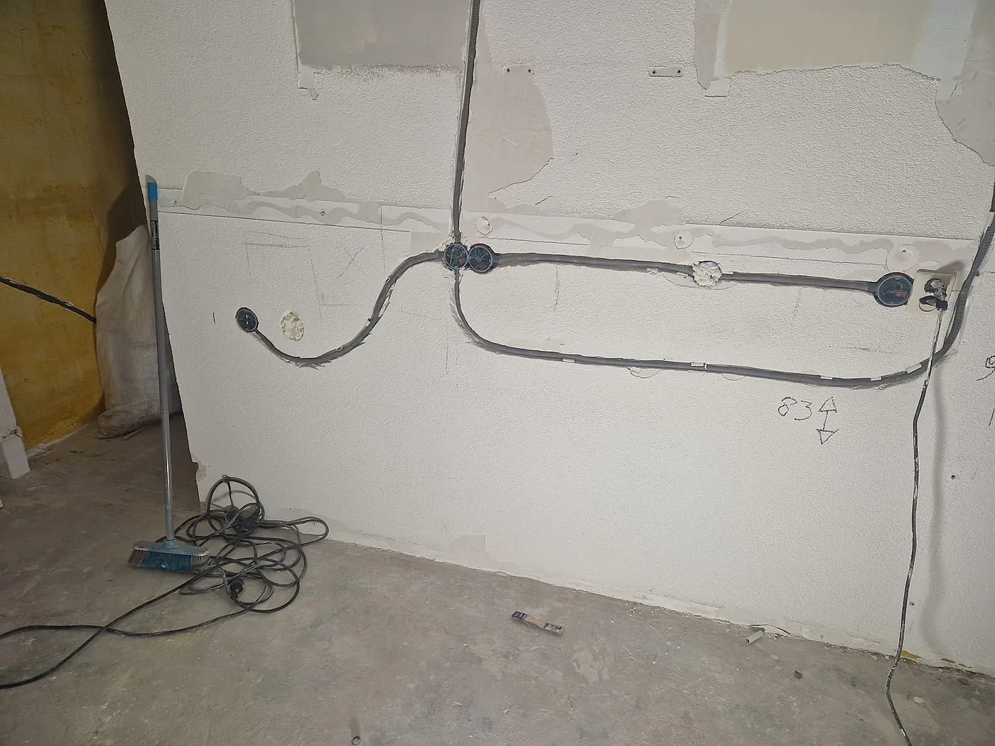 Kale wand met opbouwleidingen en inbouwdozen vóór de renovatie — keukenrenovatie in Apeldoorn door BontBouw