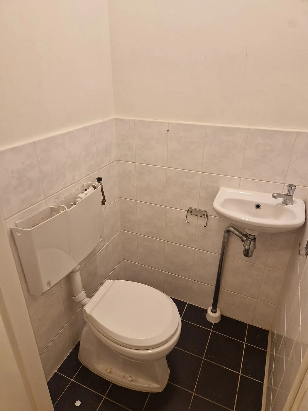 Oud toilet met lichte wandtegels vóór de renovatie — toiletrenovatie in Coendersborg door BontBouw