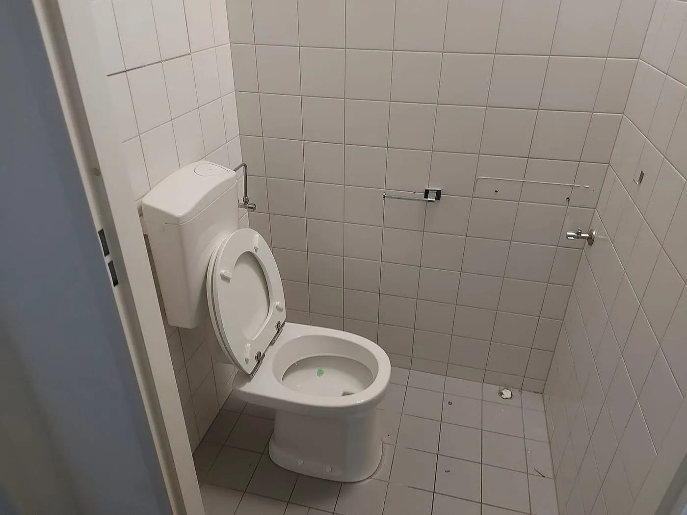 Oud toilet met opbouwreservoir en witte tegeltjes vóór de renovatie — toiletrenovatie in Schildersbuurt door BontBouw