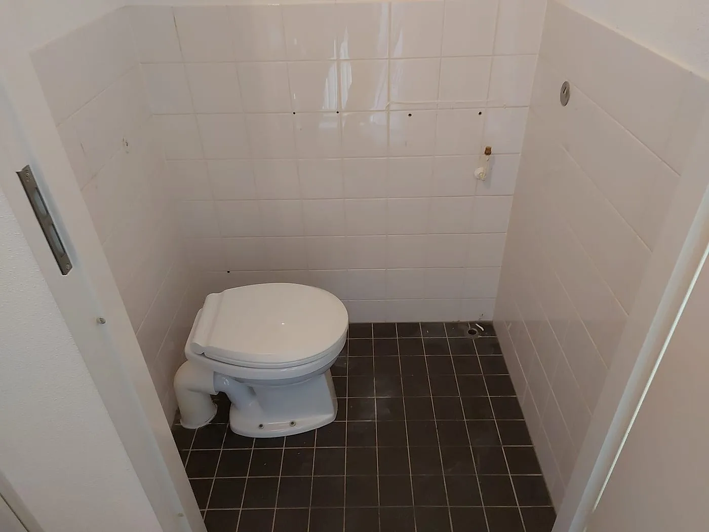 Oud toilet met staande pot en witte wandtegeltjes vóór de renovatie — toiletrenovatie in Korrewegwijk door BontBouw