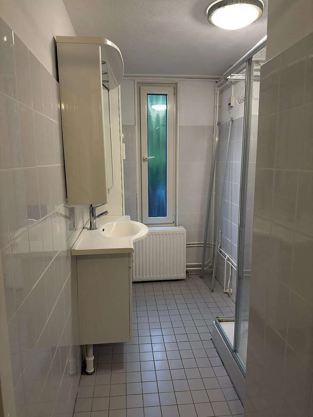 Smalle badkamer met witte tegeltjes vóór de renovatie — badkamerrenovatie in Beijum door BontBouw