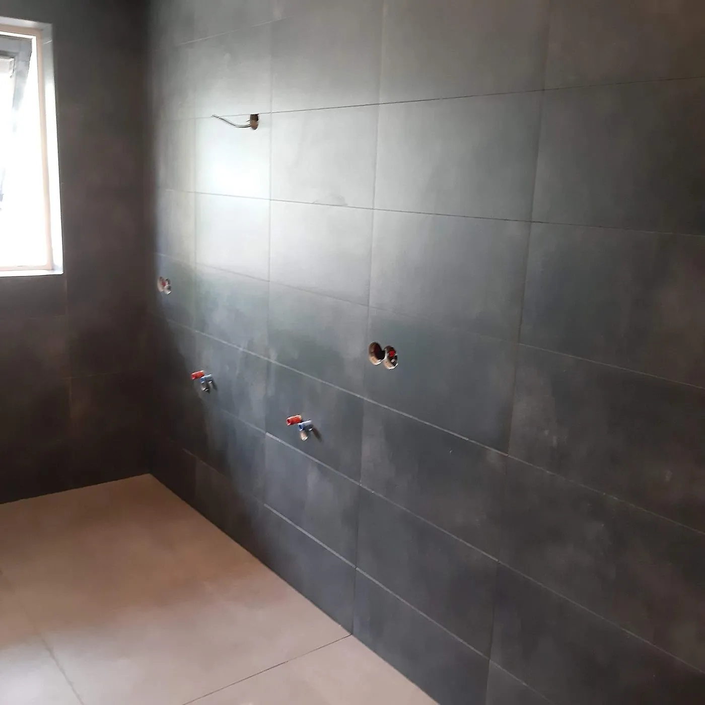 Tegelwerk met leidingaansluitingen vóór de renovatie — badkamerrenovatie in Kropswolde door BontBouw