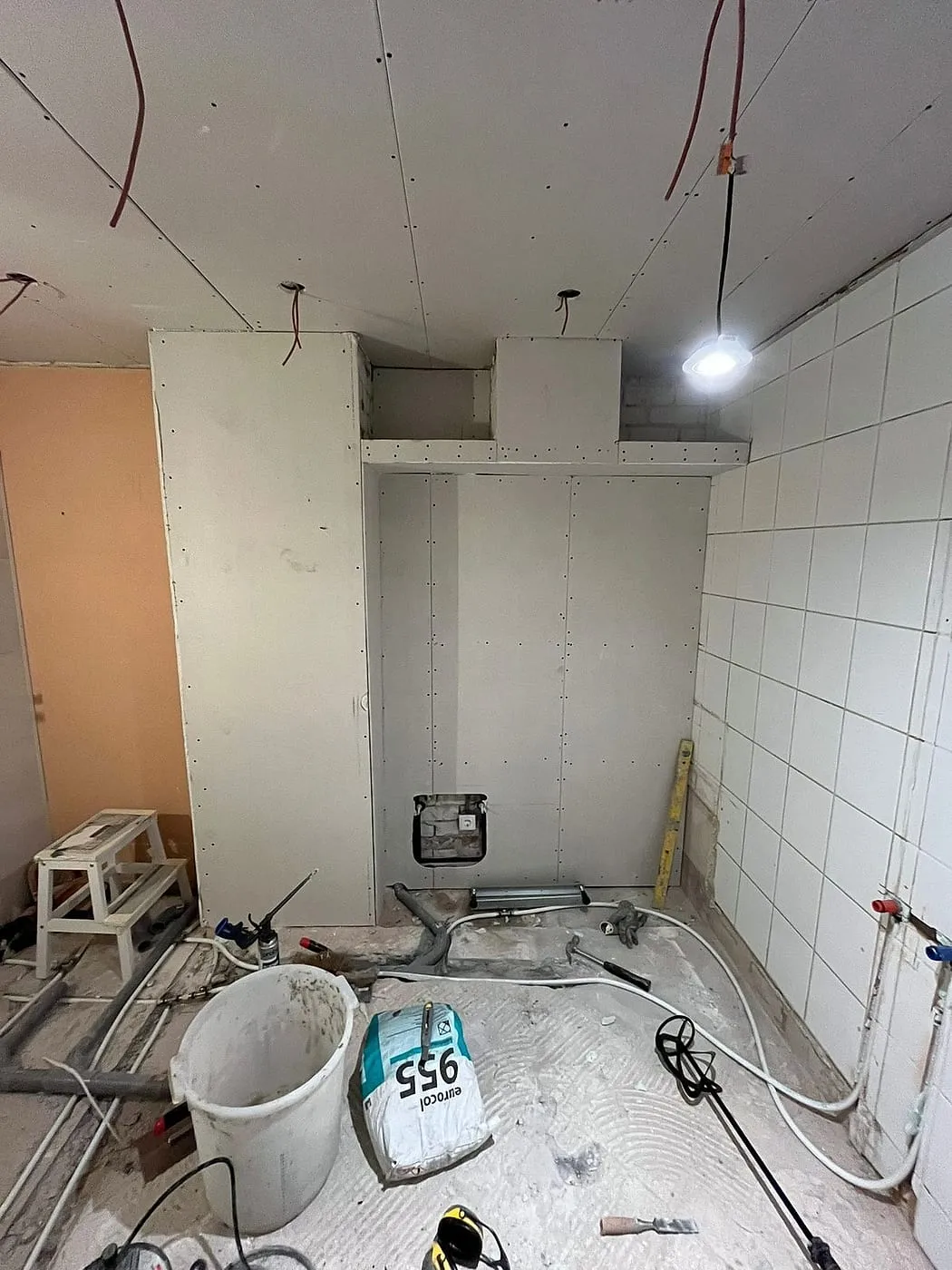 Voorzetwand in aanbouw met oude tegels vóór de renovatie — badkamerrenovatie in Corpus den Hoorn door BontBouw