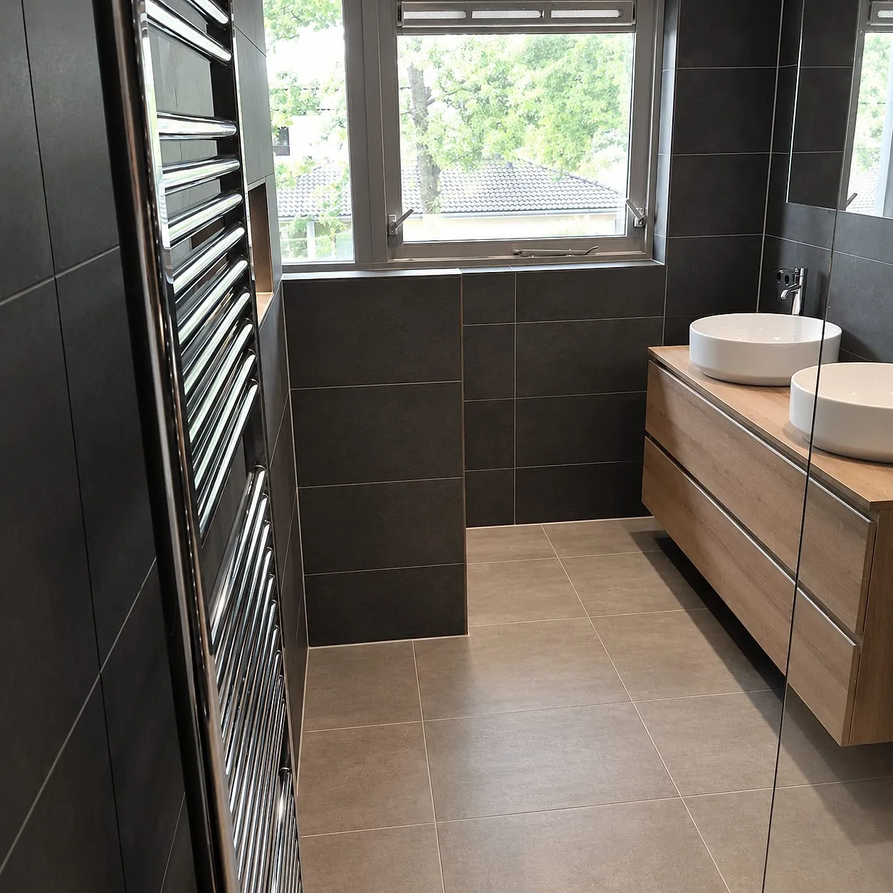 Houten wastafelmeubel bij het raam na de renovatie — badkamerrenovatie in Kropswolde door BontBouw