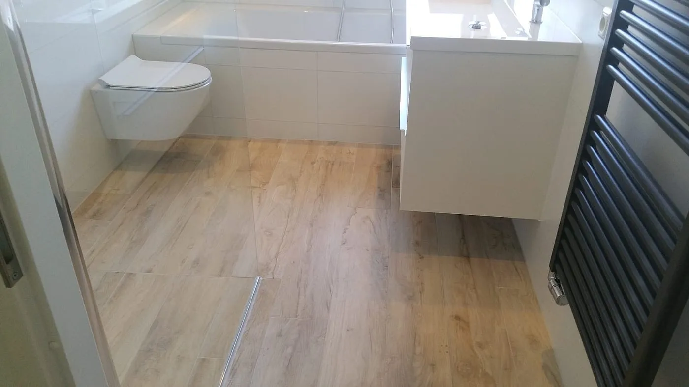 Houtlook vloertegels met douchegoot en zwevend wastafelmeubel na de renovatie — badkamerrenovatie in Haren door BontBouw