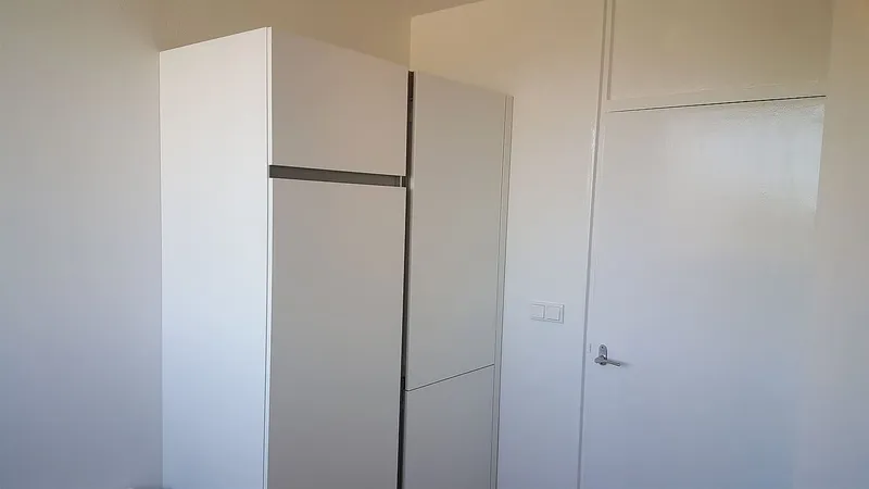 Witte hoge kastenwand met koelkast — keukenrenovatie in De Wijert door BontBouw