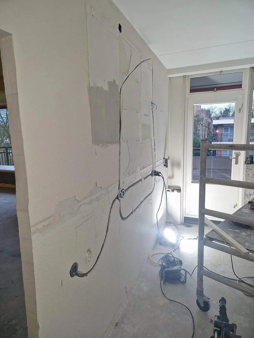 Gestucte wand met losse bedrading bij de balkondeur vóór de renovatie — keukenrenovatie in Apeldoorn door BontBouw