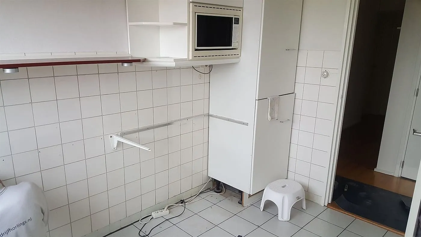 Oude keukenwand met magnetronkast vóór de renovatie — keukenrenovatie in De Wijert door BontBouw