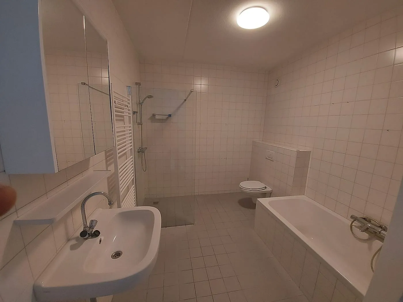 Oude wastafel en douchehoek met witte tegeltjes vóór de renovatie — badkamerrenovatie in Schildersbuurt door BontBouw