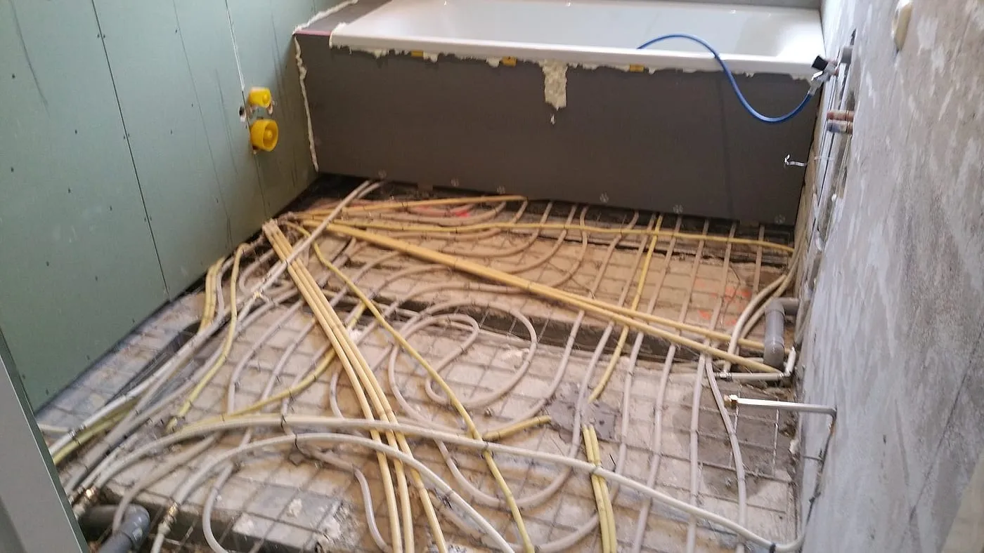 Vloerverwarmingsleidingen in de kale vloer bij het ligbad vóór de renovatie — badkamerrenovatie in Haren door BontBouw