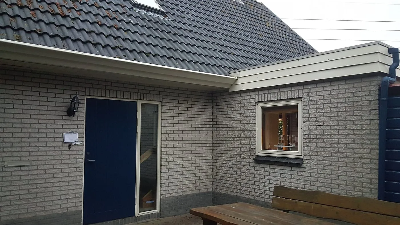 Geschilderde blauwe achterdeur met roomwitte dakrand na het werk — schilderwerk in Euvelgunne door BontBouw