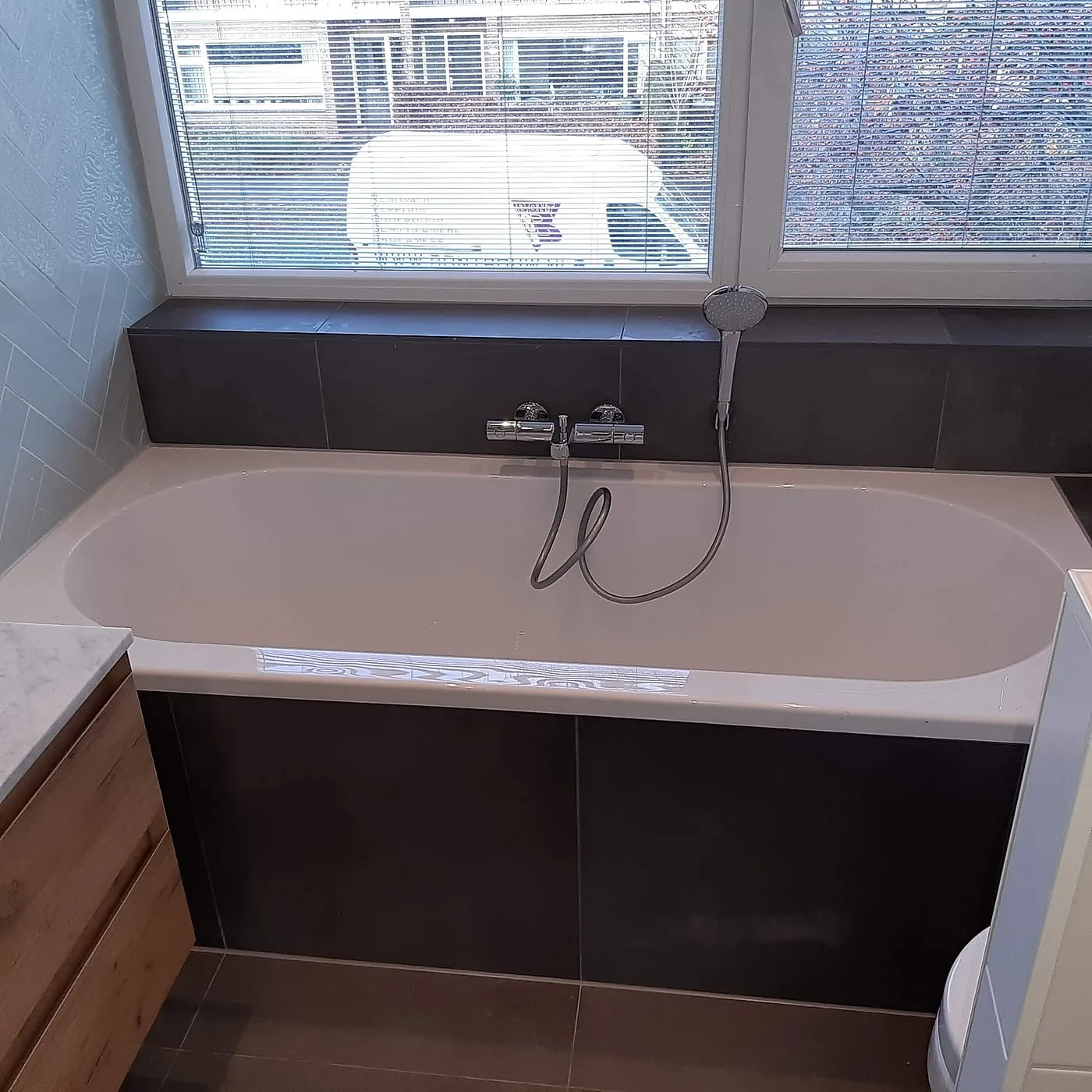 Ligbad onder het raam na de renovatie — badkamerrenovatie in Coendersborg door BontBouw