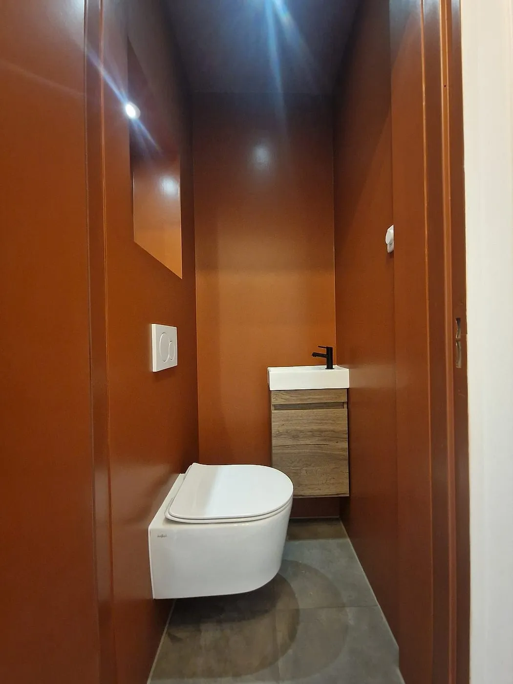 Terracotta toilet met verlichte nis na de renovatie — toiletrenovatie in Coendersborg door BontBouw