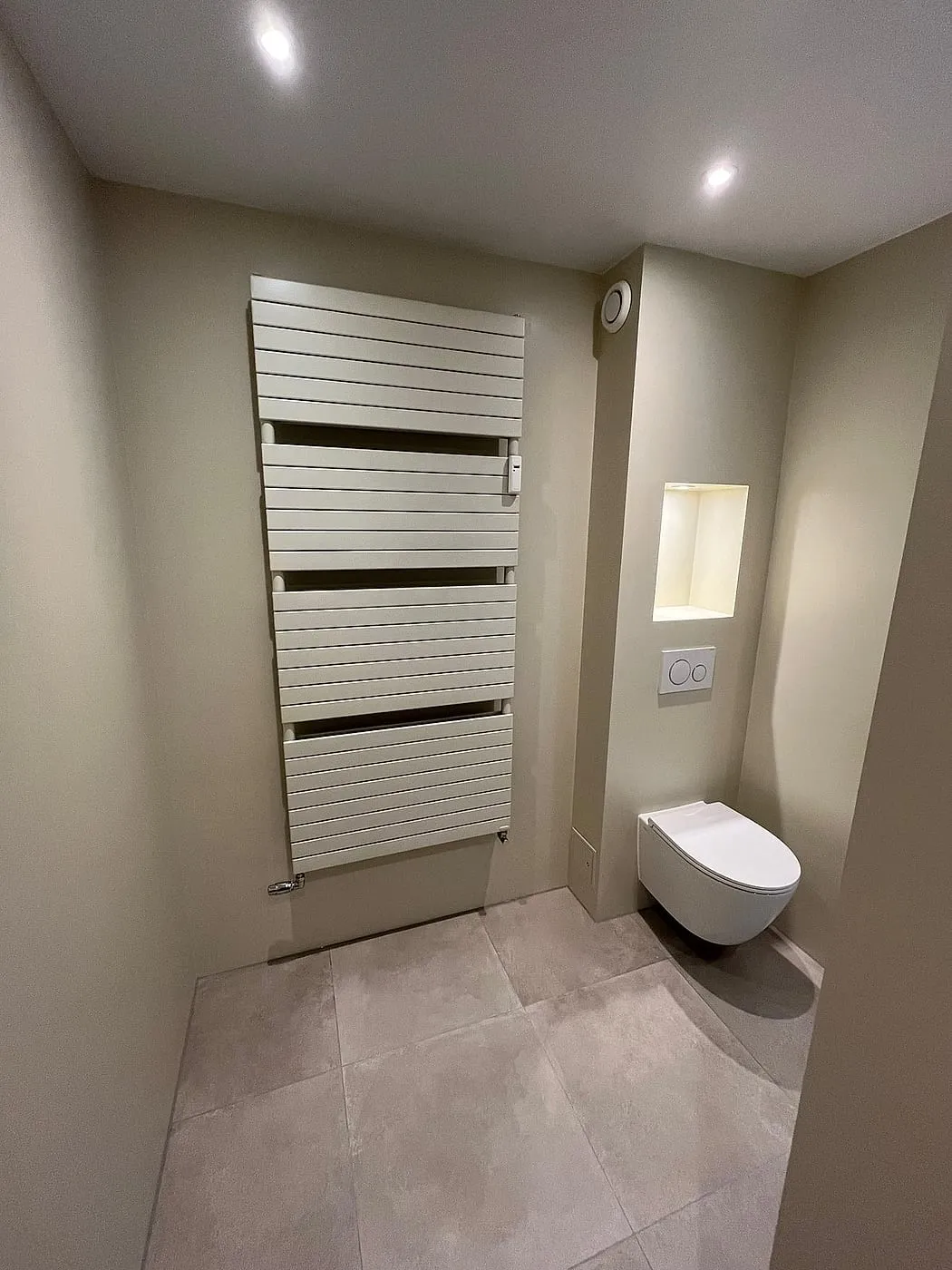Toilethoek met handdoekradiator na de renovatie — badkamerrenovatie in Apeldoorn door BontBouw