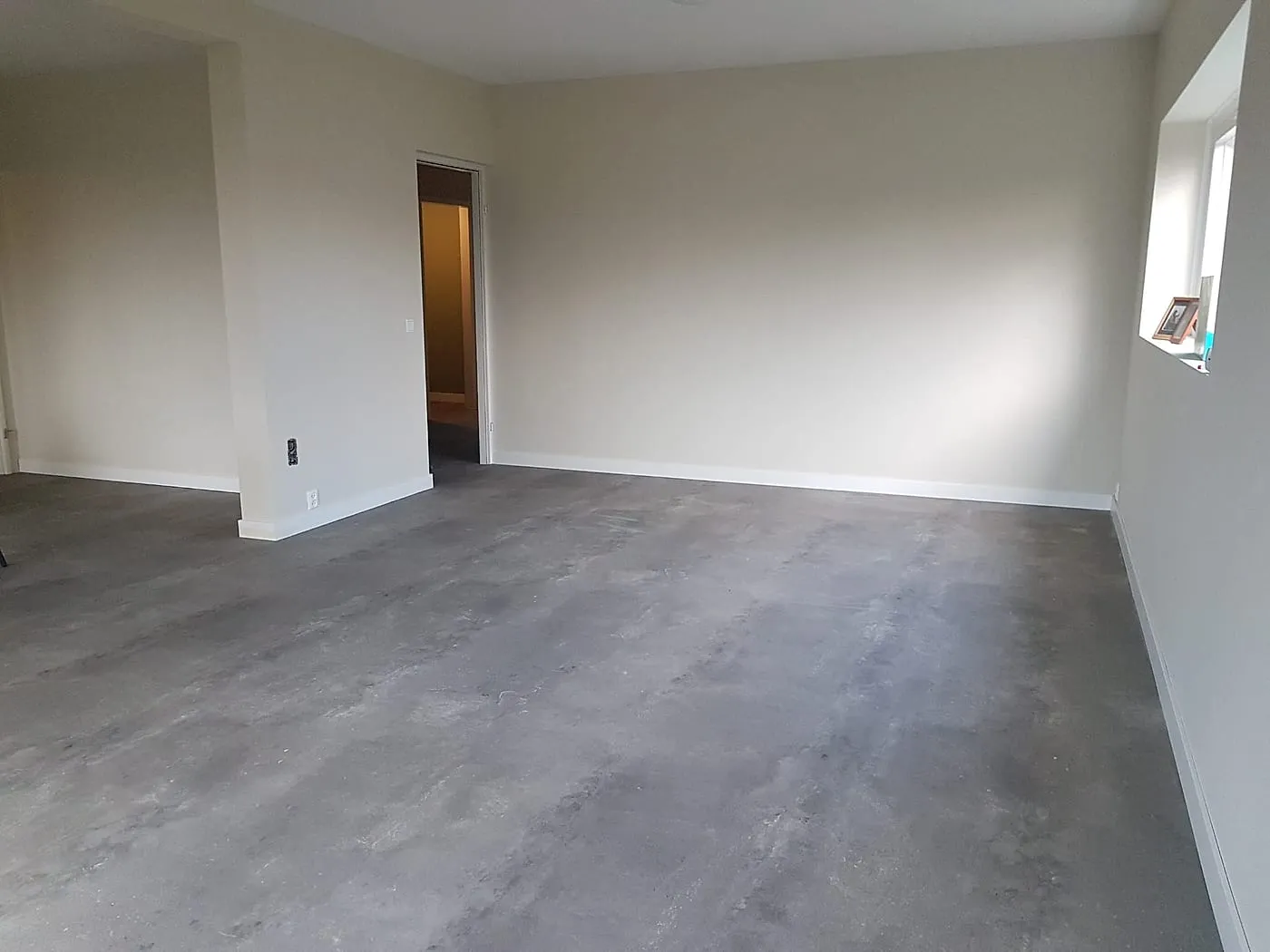 Woonkamer met grijze vinylvloer en witte wanden na de verbouwing — complete verbouwing in Apeldoorn door BontBouw