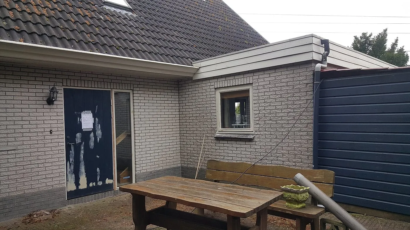 Afgeschuurde blauwe achterdeur met plamuurplekken vóór het werk — schilderwerk in Euvelgunne door BontBouw