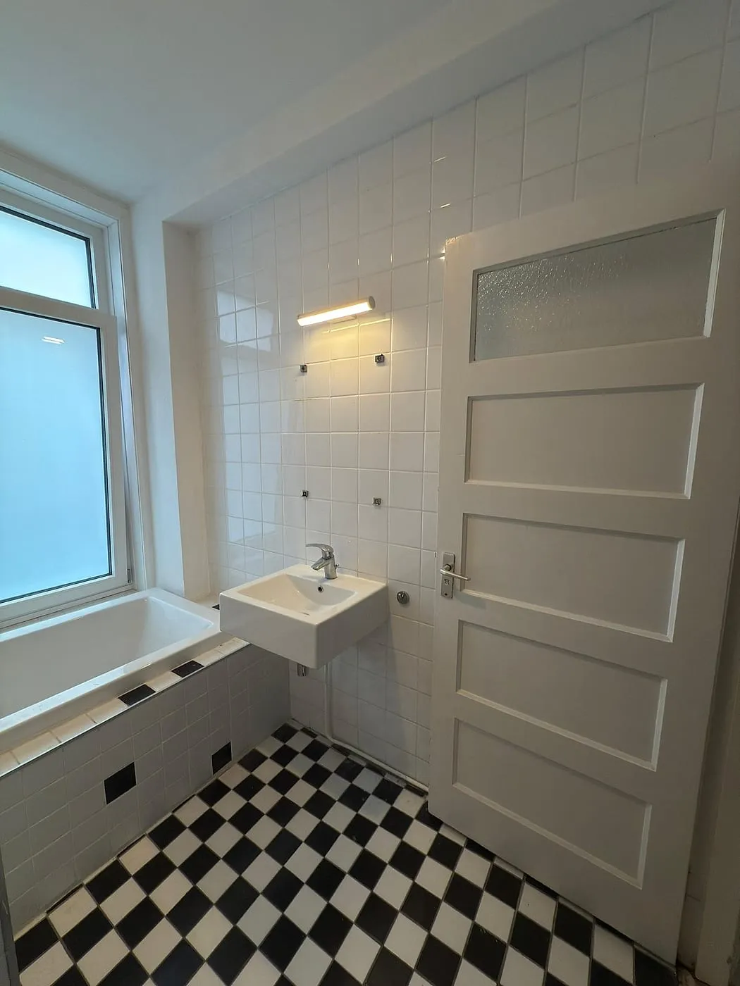 Ligbad met losse wastafel vóór de renovatie — badkamerrenovatie in Korrewegwijk door BontBouw