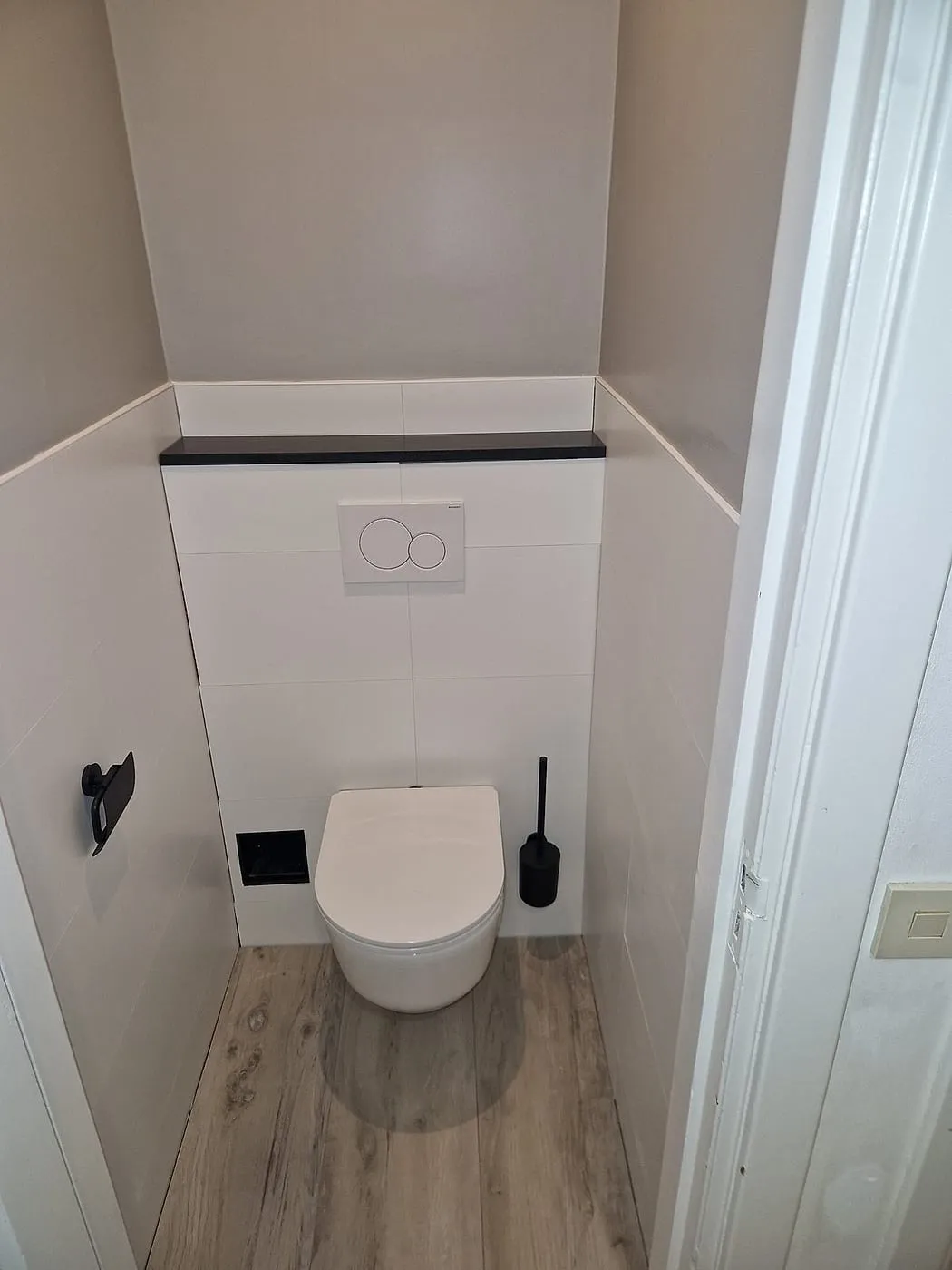 Hangend toilet met zwarte accenten na de renovatie — toiletrenovatie in Korrewegwijk door BontBouw