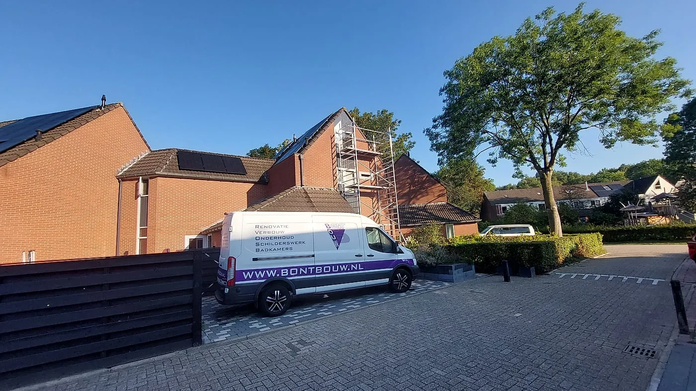 Rode voorgevel met steiger tijdens het gevelwerk vóór de verbouwing — complete verbouwing in Beijum door BontBouw