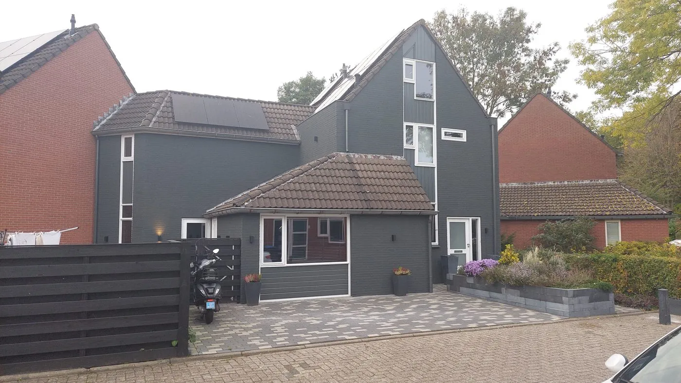 Antraciet gevel met uitbouw en zonnepanelen na het werk — schilderwerk in Beijum door BontBouw