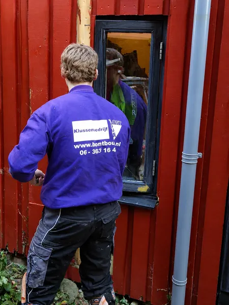 Herstel van een kozijn in een rode houten gevel door BontBouw