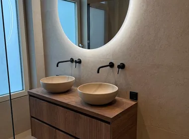 Badkamer met ronde spiegel, gerenoveerd door BontBouw in Groningen