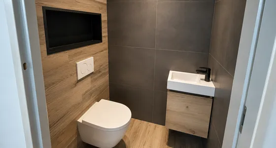 Toilet met houtlook tegels, een verlichte nis en een wit fonteintje