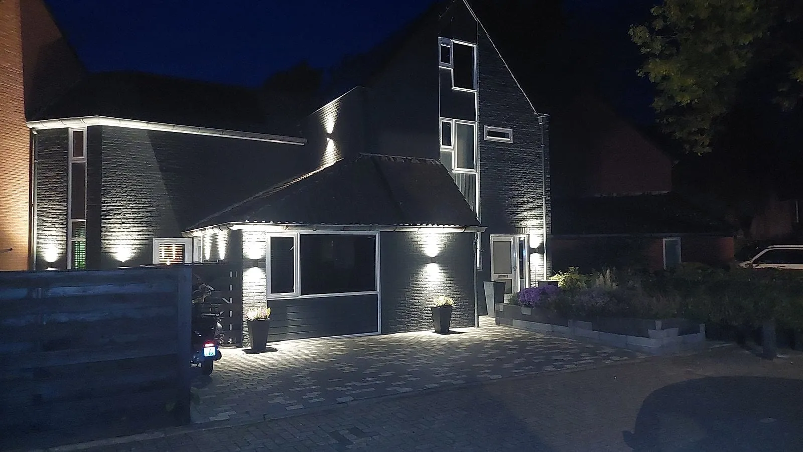 Antraciet geschilderde bakstenen gevel bij avond, schilderwerk door Bontbouw in Groningen