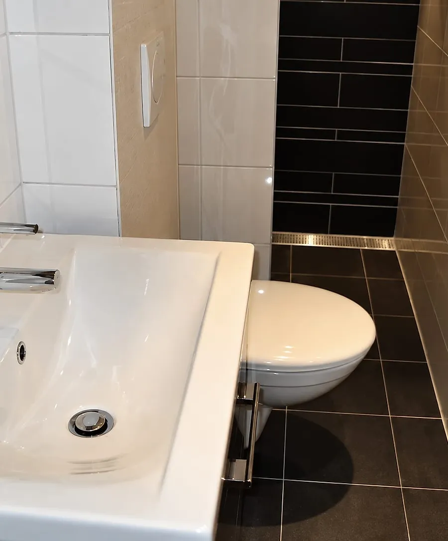 Badkamer met donkere tegelwand in Groningen — badkamerrenovatie door BontBouw