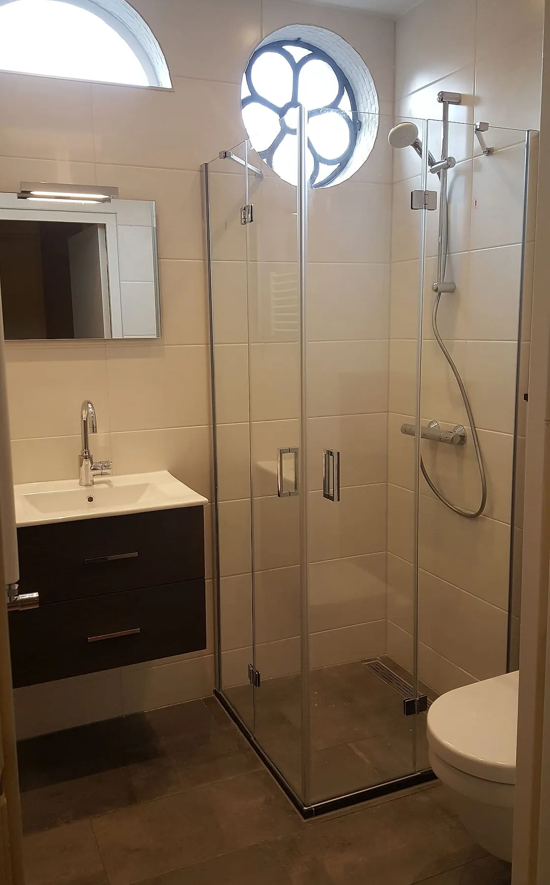 Douchecabine met glazen vouwdeuren naast de wastafel na de renovatie — badkamerrenovatie in Oosterpoort door BontBouw