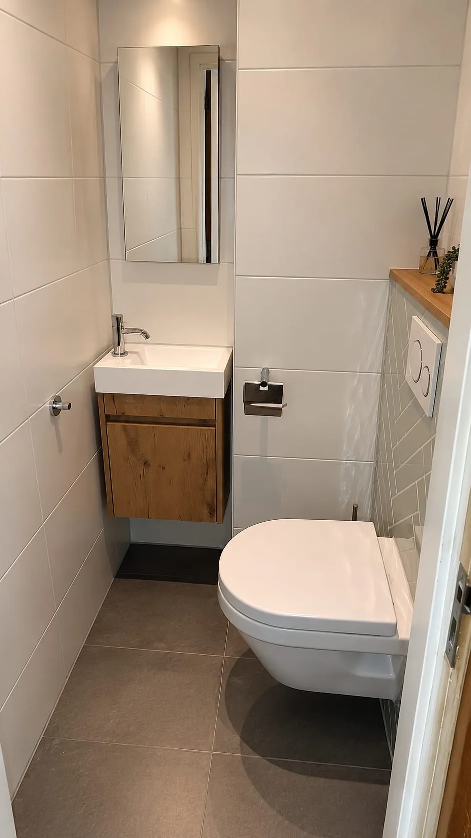 Fonteinmeubel in eikenlook met spiegel en hangtoilet na de renovatie — toiletrenovatie in Coendersborg door BontBouw