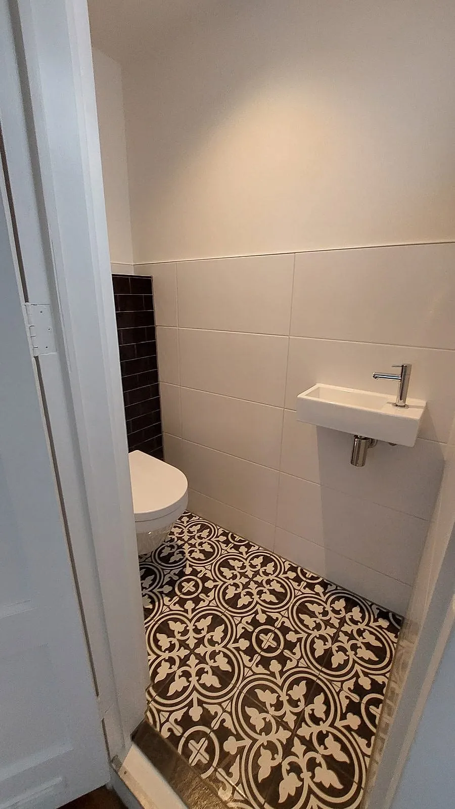 Hangtoilet met portugese patroontegels en witte wandtegels na de renovatie — toiletrenovatie in Korrewegwijk door BontBouw