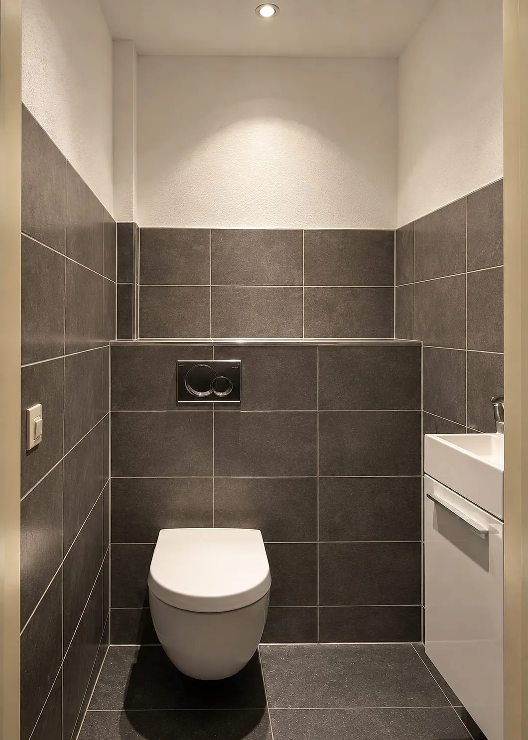 Hangtoilet met taupe wandtegels en wit fonteinmeubel na de renovatie — toiletrenovatie in Groningen door BontBouw