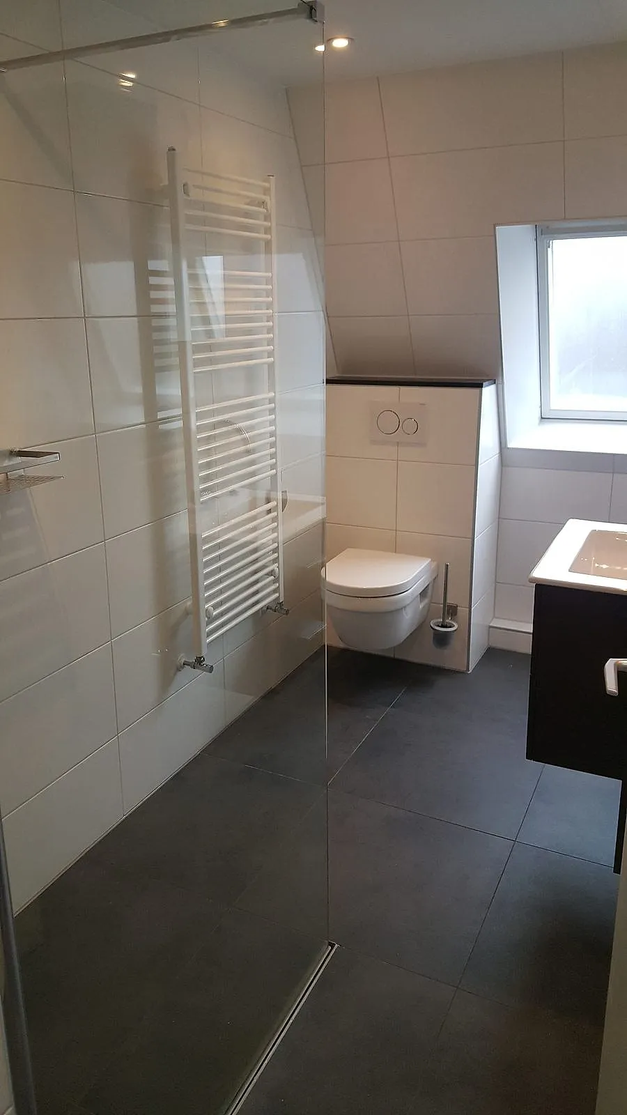 Inloopdouche met glazen wand en antracieten vloertegels na de renovatie — badkamerrenovatie in De Hoogte door BontBouw