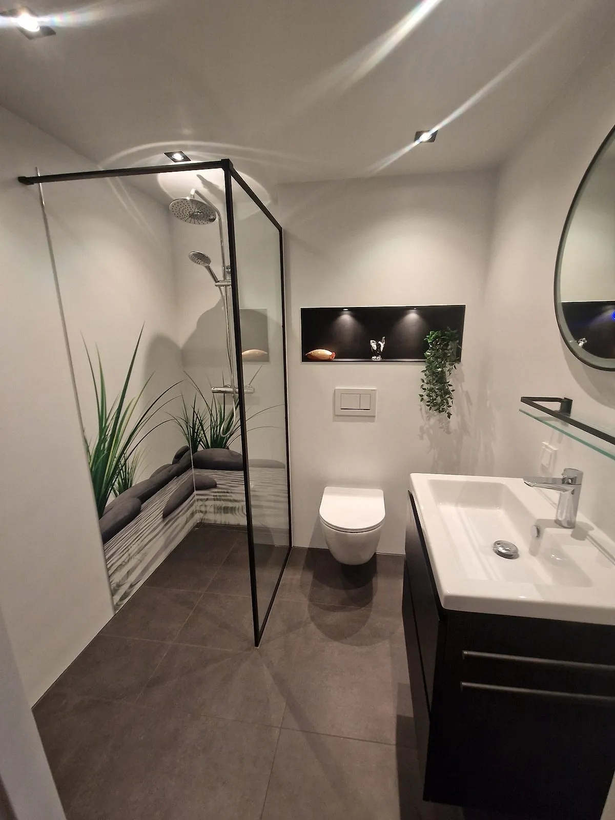 Inloopdouche met zwart omlijste glaswand en verlichte nis na de renovatie — badkamerrenovatie in De Hunze door BontBouw