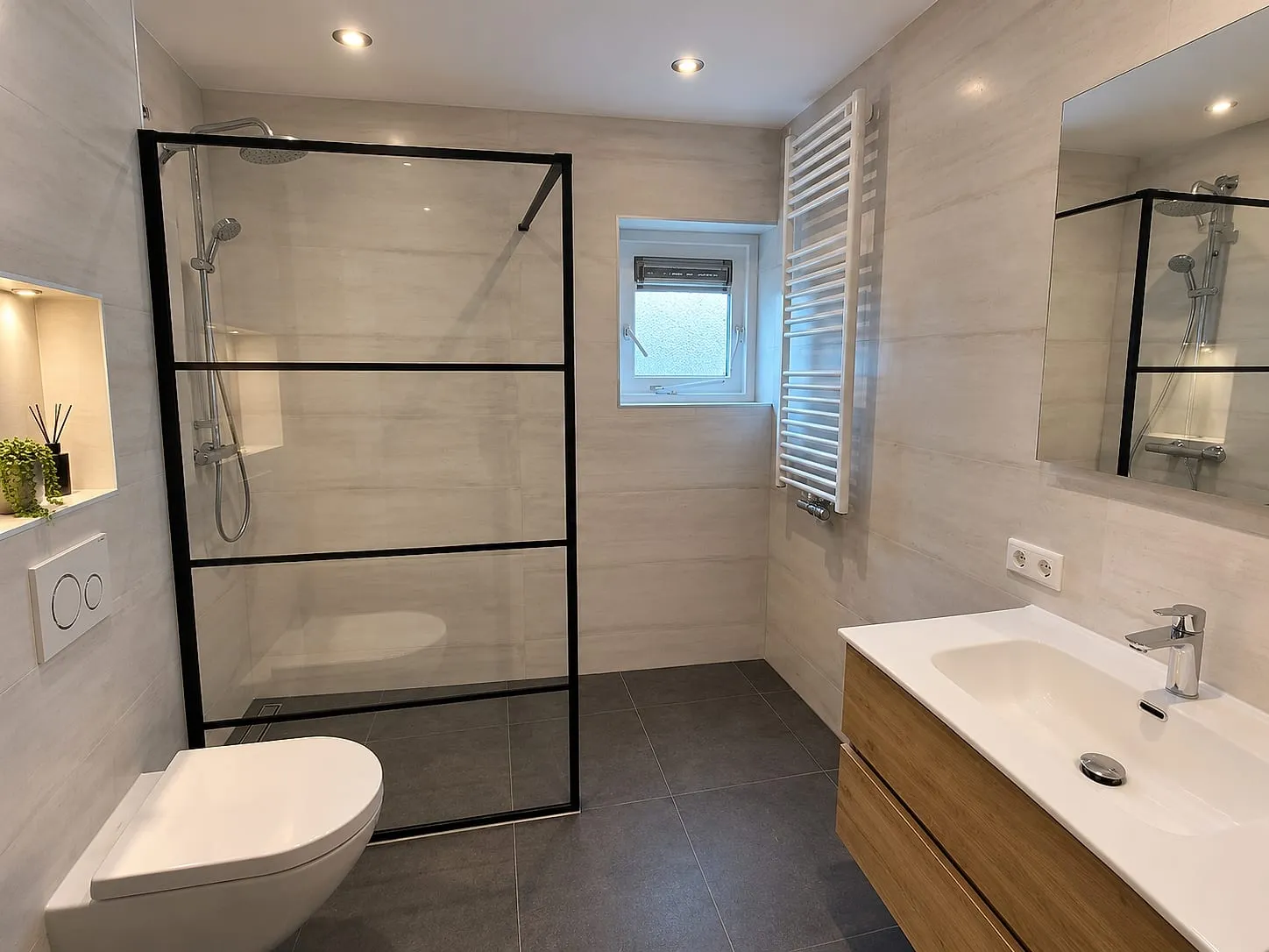 Inloopdouche met zwart stalen wand na de renovatie — badkamerrenovatie in Hoogkerk door BontBouw