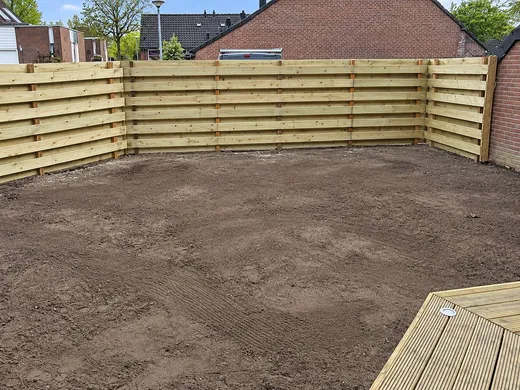 Houten schutting rond een open hoektuin in Beijum