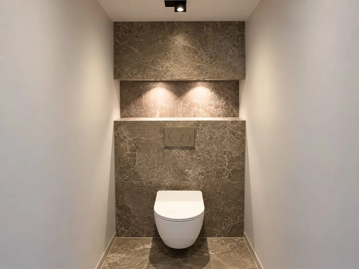 Toilet met marmerlook en verlichte nis na de renovatie — toiletrenovatie in Westerhaven door BontBouw