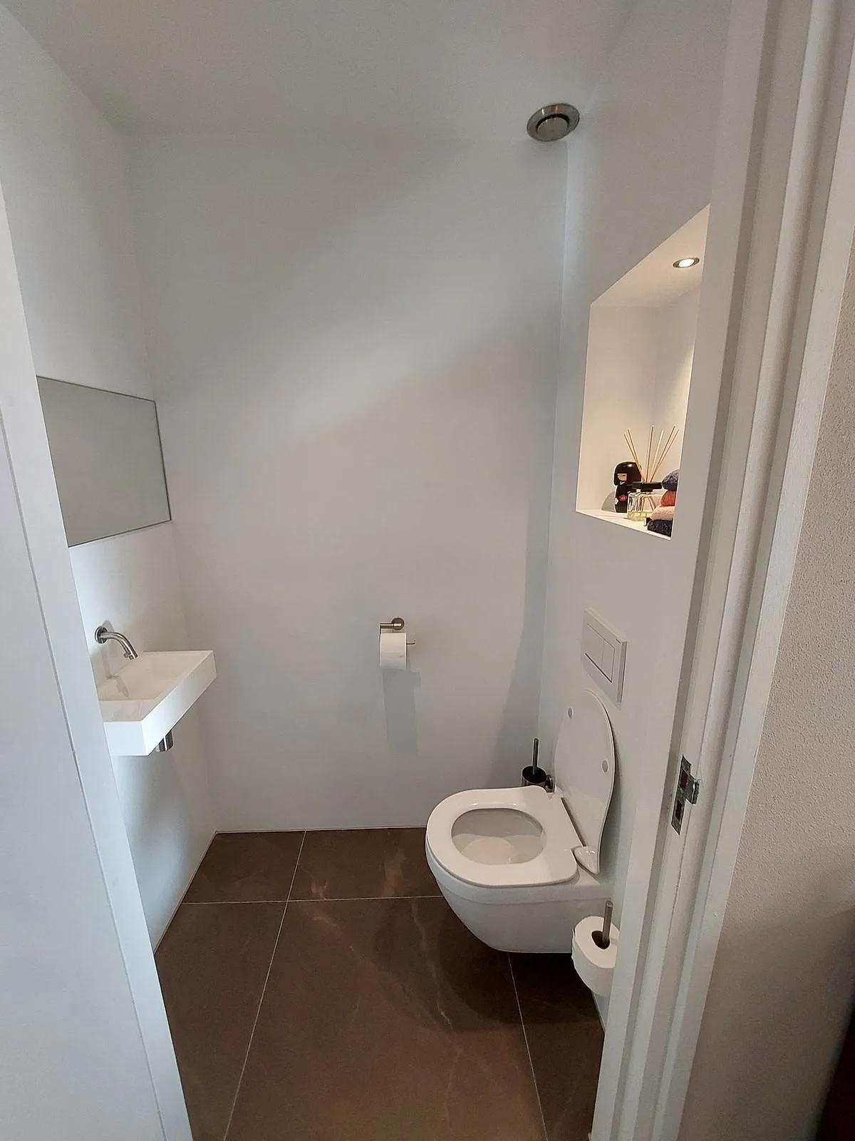 Wit toilet met verlichte nis na de renovatie — toiletrenovatie in Eelderwolde door BontBouw
