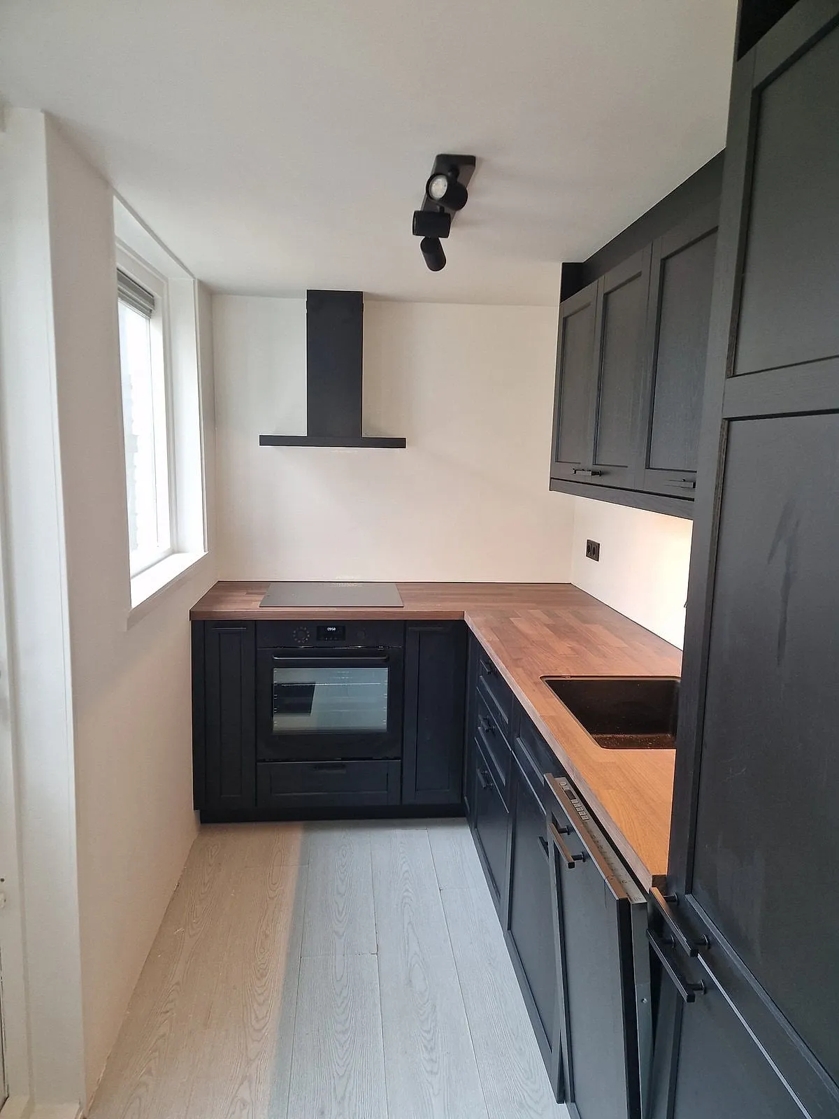 Zwarte keuken met houten blad na de renovatie — keukenrenovatie in Leeuwarden door BontBouw