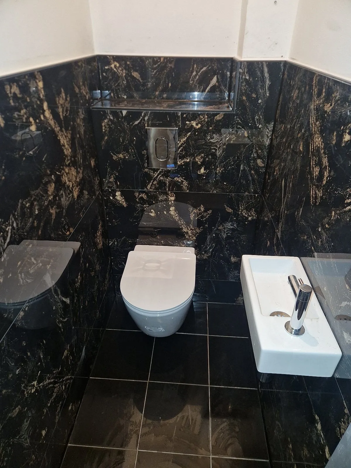 Toilet met zwart marmeren tegels na de renovatie — toiletrenovatie in Lewenborg door BontBouw