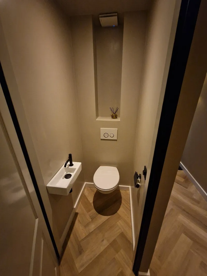 Toilet met visgraatvloer en hoge nis in Beijum — toiletrenovatie door BontBouw